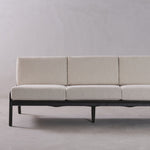 Beige sofa with black frame on a plain background
