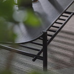 Round metal table with a textured surface on a carpeted floor