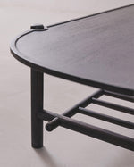 Black metal shelf with curved design on a light gray background