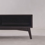 Dark wooden TV stand against a plain wall