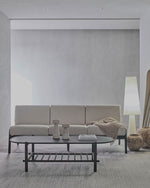 Modern living room with a beige sofa, coffee table, and decorative items.