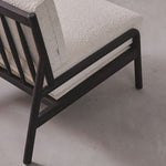 Sofa with textured beige cushions and dark wooden frame on a gray background