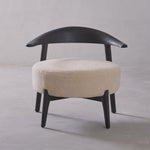 Chair with black frame and beige cushion on a gray background
