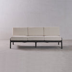 Beige sofa with black frame on a plain gray background