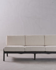 Beige sofa with black frame on a plain background