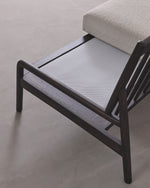 Modern lounge chair with beige cushion on a light gray background