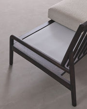 Modern lounge chair with beige cushion on a light gray background