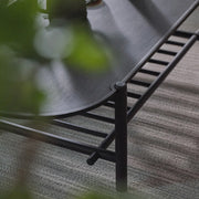 Round metal table with a textured surface on a carpeted floor
