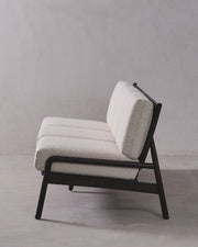Gray upholstered chair with black frame on a gray background
