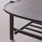 Black metal shelf with curved design on a light gray background