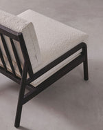 Sofa with textured beige cushions and dark wooden frame on a gray background