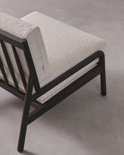 Sofa with textured beige cushions and dark wooden frame on a gray background