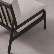 Sofa with textured beige cushions and dark wooden frame on a gray background