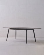 Round glass table with metal legs on a white background