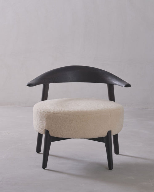 Chair with black frame and beige cushion on a gray background