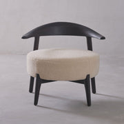 Chair with black frame and beige cushion on a gray background