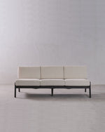 Beige sofa with black frame on a plain gray background