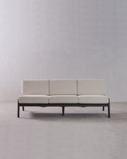 Beige sofa with black frame on a plain gray background